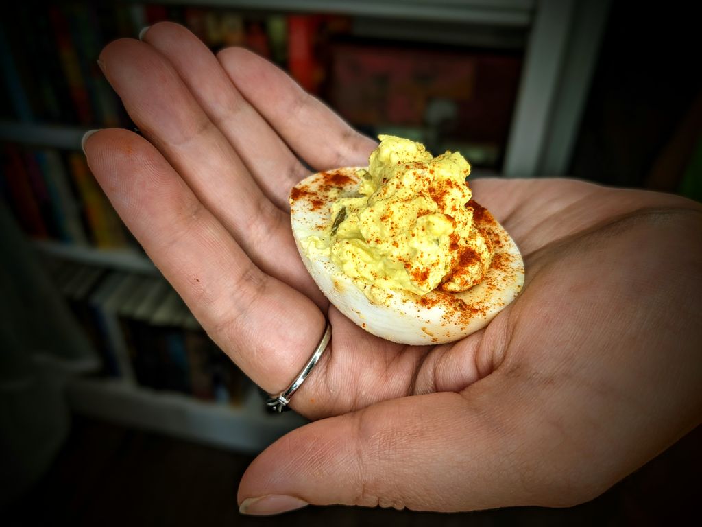 Hand holding deviled egg